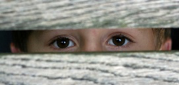 child looking through a fence