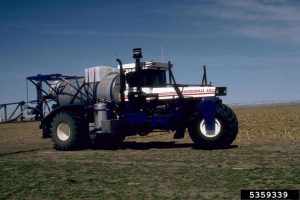 herbicide sprayer driving through field