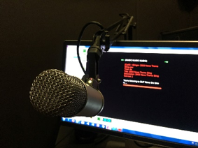 Microphone on a boom in front of a computer screen