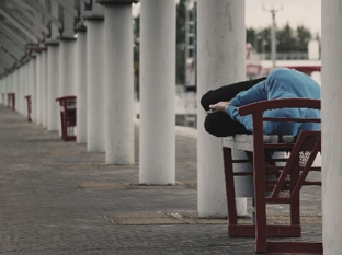 A person sleeping on a bench outside