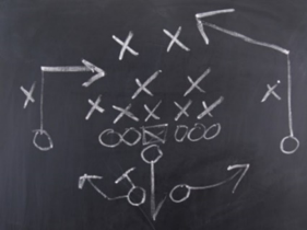 diagram of a football play drawn on a chalkboard