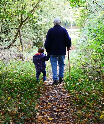 a grandfather walking with his grandson in the woods