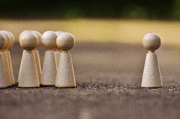 little people made out of wood dowels, with one on the right being separate from the others