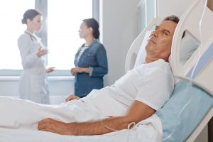 Middle-aged man in hospital bed after having a heart attack.
