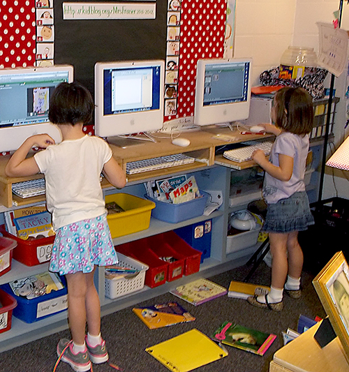 Two first grade female students using computers in a classroom