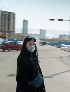 A woman stands in Ulaanbaatar wearing a mask to protect from pollution.