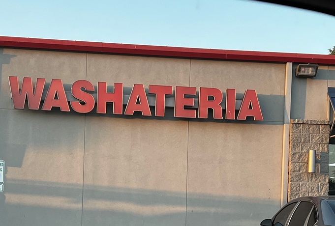 Picture of a laundromat with the words "Washateria."