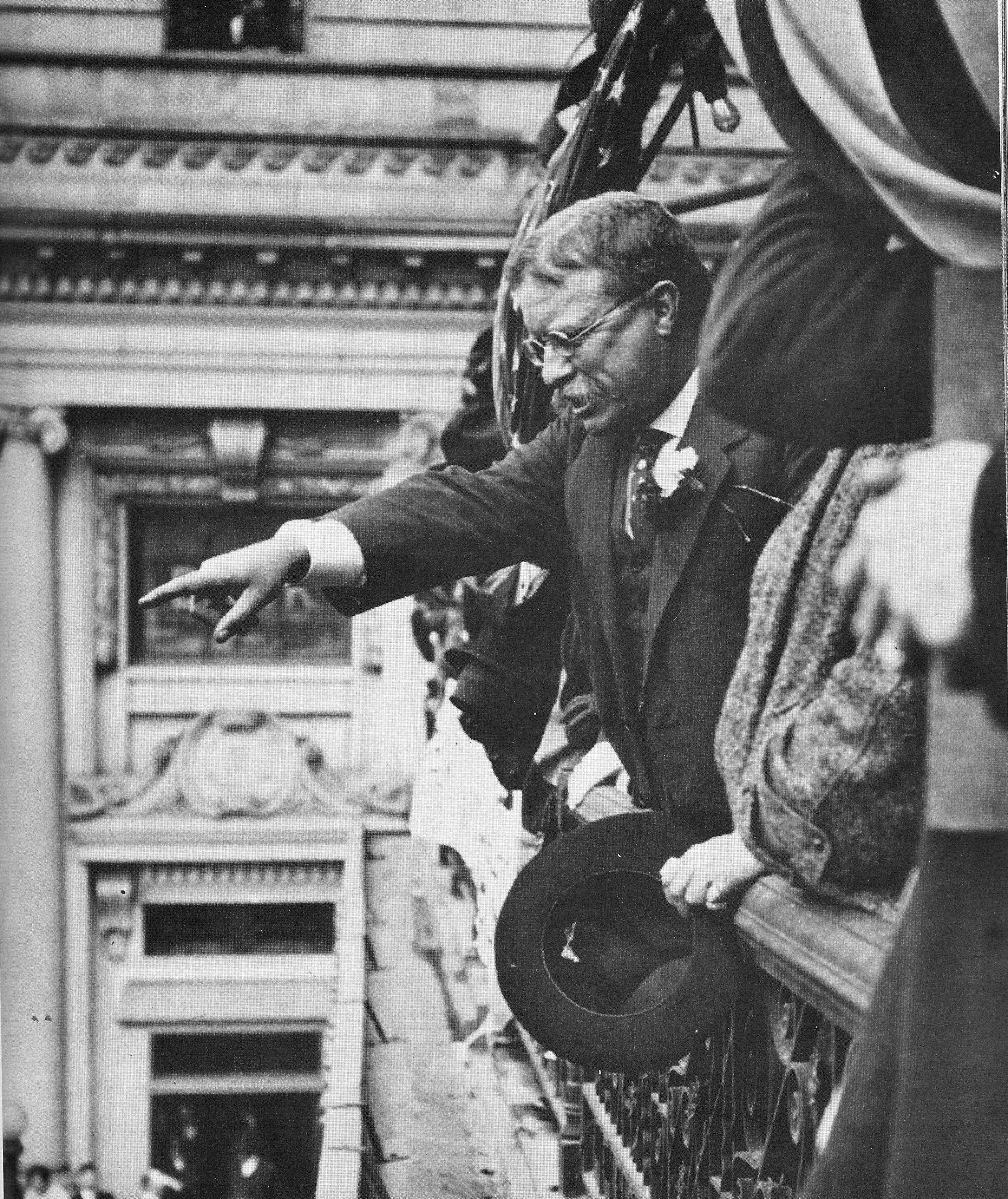 Teddy Roosevelt pointing at the crowd outside a balcony