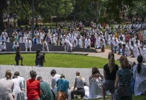 A photo of medical professionals and others kneeling at the University of Virginia's Memorial to Enslaved Laborers.