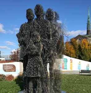 Columbus Ohio racial justice park monument, with a girl and three adults standing.