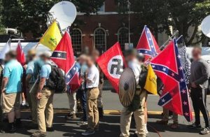 A photograph of demonstrators carrying Nazi and Confederate flags.