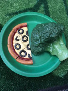 image: broccoli sitting next to pizza