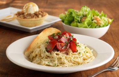 image: Restaurant meal with salad, pasta dish, and cobbler