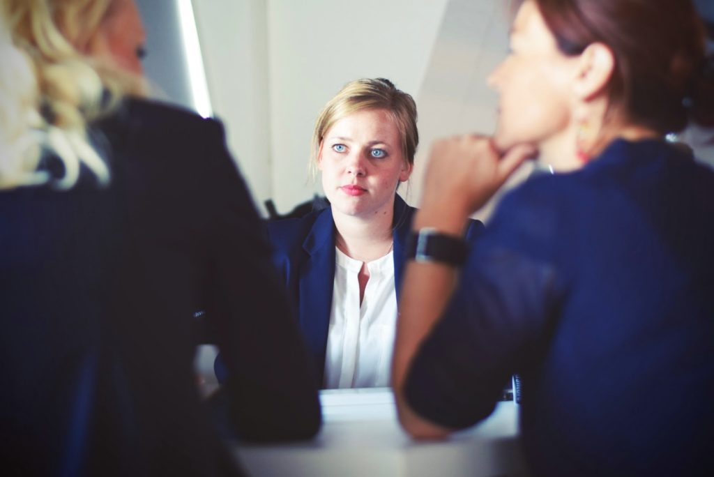 Woman across table from two interviewers