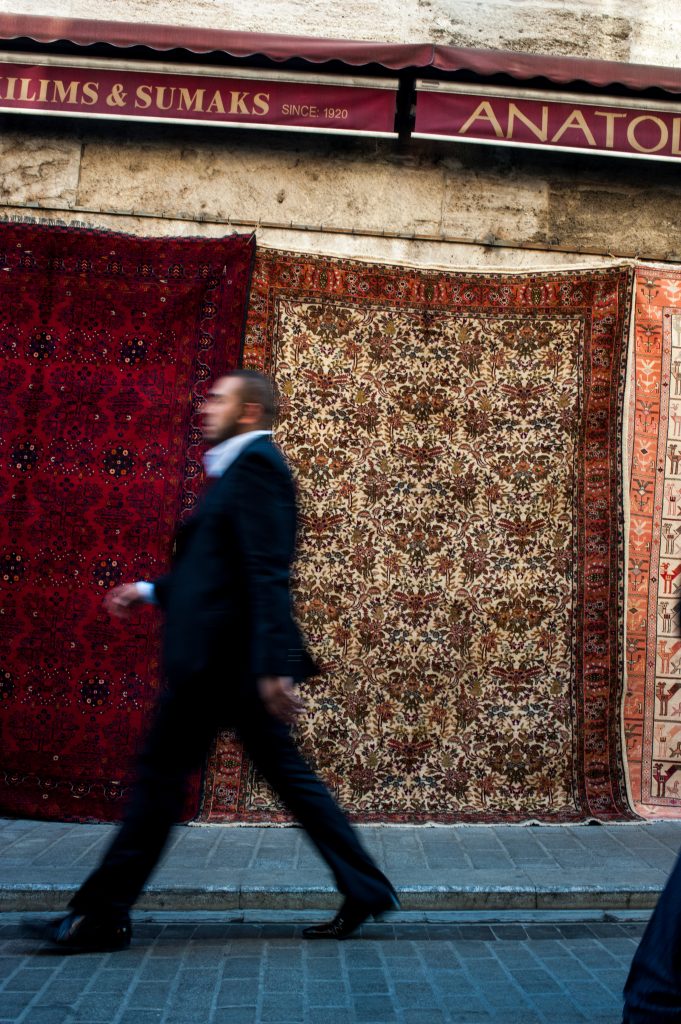 image of carpets hanging on Istanbul street,man walking