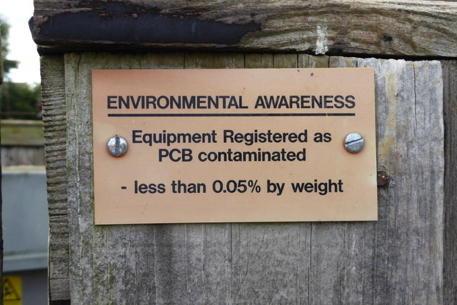 sign bolted to a wooden post that reads "environmental awareness, equipment register as PCB contaminated, less than 0.05% weight."